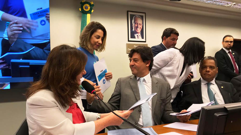 Representante do IVOC entregando documento sobre a campanha #simparaquimiooral ao ministra da Saúde Henrique Mandetta.