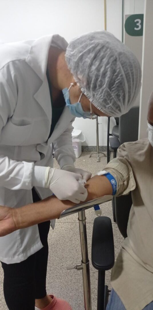 Imagem mostra: enfermeira realizando o precedimento de coleta de sangue.